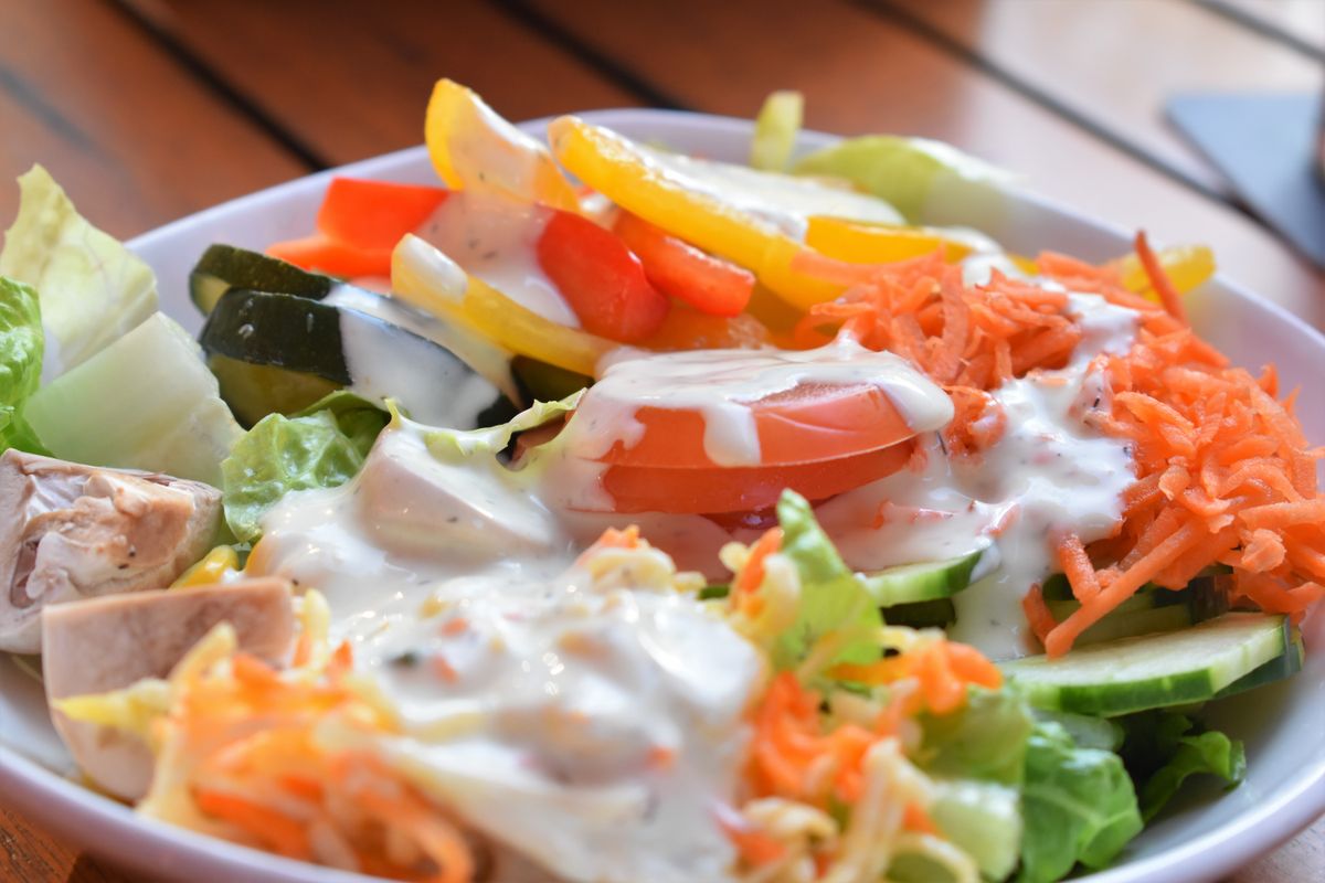 A green salad tossed through until every leaf is coated in dressing